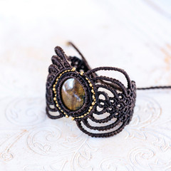 Stylish boho macrame string natural mineral stone bracelet on white decorative background