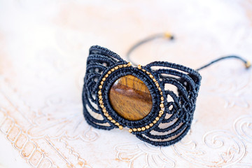 Fototapeta premium Stylish boho macrame string natural mineral stone bracelet on white decorative background