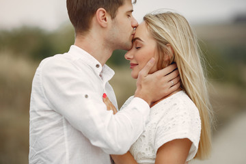 Cute couple in a field. Lady in a white dress. Guy in a white shirt