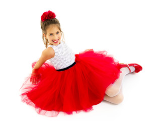 Little girl lies on the floor.Studio photo shoot on a white back