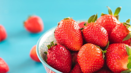 bowl of fresh strawberries on a wooden table