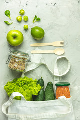 Zero waste concept. Eco-friendly shopping, flat lay. Fresh organic green vegetables and fruits on gray background. Spring diet, healthy raw vegetarian, vegan concept, alkaline clean eating