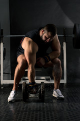 Powerlifter with strong arms is preparing a weightlifting. Muscular man training in the gym. Healthy lifestyle concept.