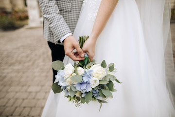 Beautiful wedding bouquet in the hands of the bride and groom