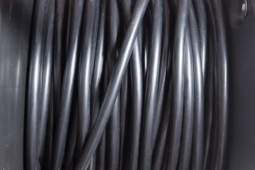 Black electrical extension cord on a take-up reel with four sockets