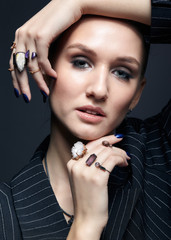 Young woman with many bijouterie rings with stones on fingers