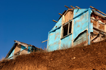 Fototapeta premium small dilapidated house on a background of blue sky
