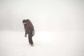 Fototapeta na wymiar Mountaineer girl in the snow, is cold