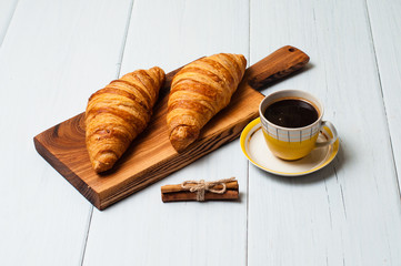 Croissants and coffee on light background. Concept delicious breakfast or lunch