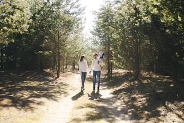 Obraz premium Happy girl and guy with tourist backpack and guitar walking in nature, travel love story concept, selective focus