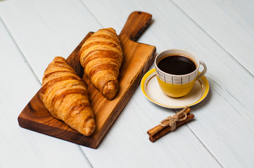 Croissants and coffee on light background. Concept delicious breakfast or lunch