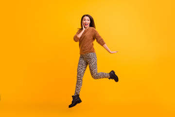 Fototapeta na wymiar Full body profile photo of funky lady jumping up high good mood youth look addicted shopper wear fluffy sweater leopard trousers boots isolated yellow color background
