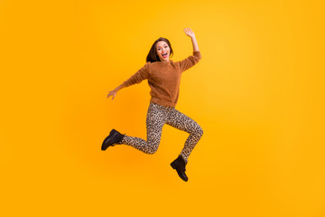 Fototapeta na wymiar Full size photo of crazy funky lady jumping up high party mood cheerful person weekend rejoicing wear fluffy sweater leopard pants shoes isolated yellow color background