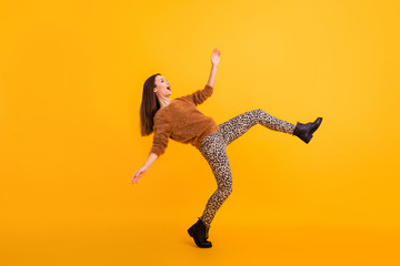 Fototapeta na wymiar Full size profile photo of funky lady raising leg high trend look dancing like robot almost falling down wear fluffy sweater leopard trousers shoes isolated yellow color background