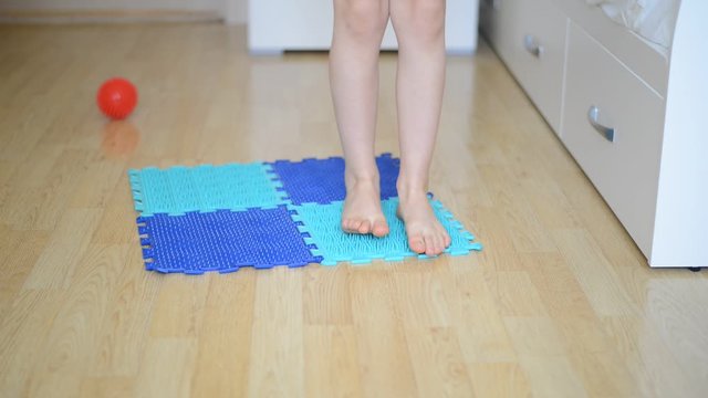 feet correction - kid walking on orthopedic massage mat
