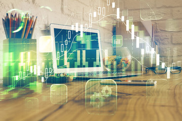 Double exposure of graph and financial info and work space with computer background. Concept of international online trading.