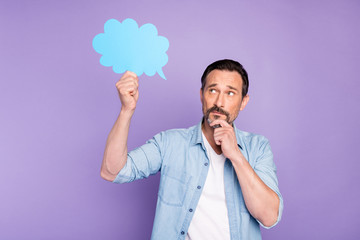 Portrait of pensive man hold blue paper card speech bubble think thoughts touch chin fingers wear good looking clothing isolated over violet color background