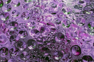 Purple blurred abstract background with drops on glass