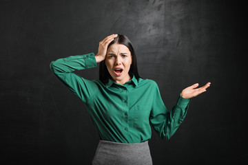 Stressed female teacher near blackboard in classroom