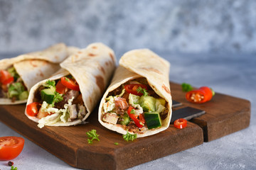 Burrito - mexican dish with corn tortilla, jasse, vegetables and sauce. Tortilla stuffed.