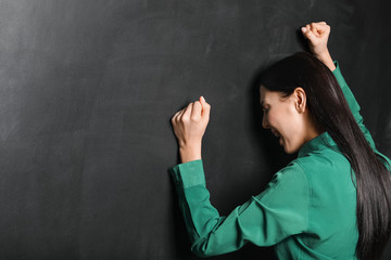 Female teacher in despair near blackboard