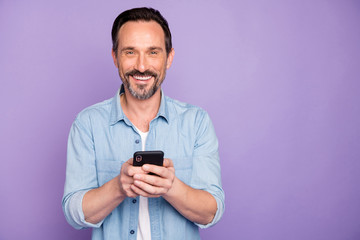 Portrait of positive cheerful man use cell phone have rest relax text type sms chatting with...