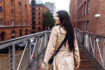 Beautiful stylish girl walks in the city of Norway on a sunny day. Young woman enjoys a stunning...