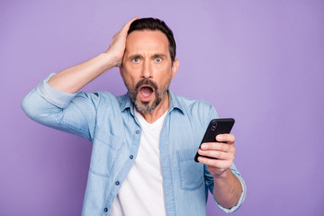 Portrait of impressed shocked man use cellphone read unbelievable news scream wow omg touch head...