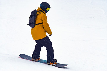 man close-up snowboarding in winter, in a yellow jacket. winter sports, extreme sports,...
