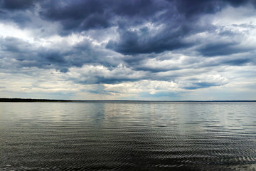 Obraz premium Moon shining through dark clouds over water, atmospheric background.