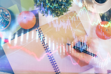 Forex chart hologram on hand taking notes background. Concept of analysis. Double exposure
