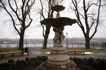 Ancient fountain in the city of Narva. It's a nasty day. Added grain effect.