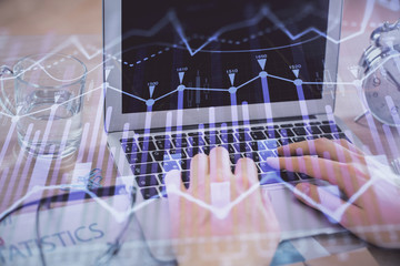 Multi exposure of market chart with man working on computer on background. Concept of financial analysis.