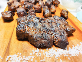 entrecote beef steak sliced with salt close up on a modern wooden cutting Board.