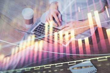 Forex graph with businessman working on computer in office on background. Concept of analysis. Double exposure.