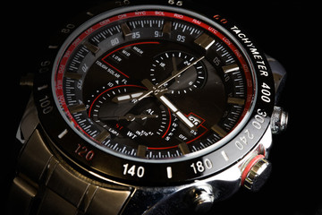 Fototapeta premium Luxury sport chronograph black Analog Men's Watch silver red steel for men luxury on black background - detail view