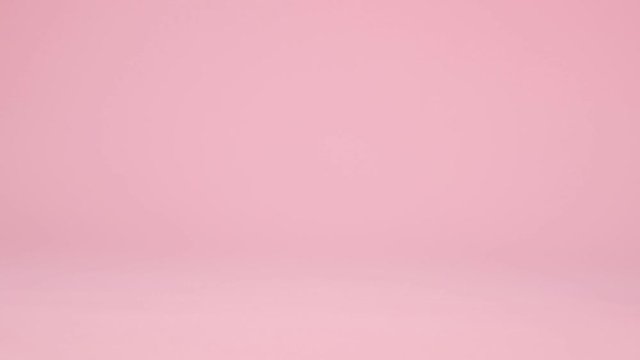 Red toy model car with a golden pattern egg on a pink background. Happy easter concept. Gift delivery.