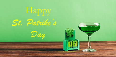 Traditional drink green beer in glass calendar the date March 17 and the text Happy St. Patrick's...