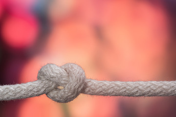 Sailor knot and rope in front of an orange bokeh background	