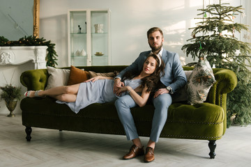 Obraz premium Attractive and loving man and girl on the background of the Christmas tree at home, the concept of Christmas love story