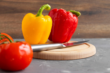 Fresh yellow and red paprika peppers on concrete background
