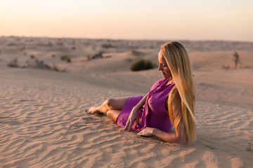 Fototapeta na wymiar Blonde model in the desert in Emirates