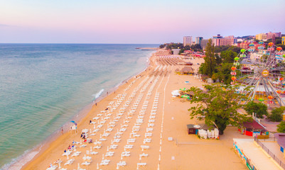 Aerial top view on the sandy beach. Umbrellas, sand and sea waves landscape.