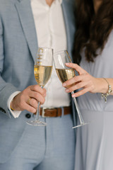 Attractive and loving man and girl on the background of the Christmas tree at home with glasses of champagne, the concept of Christmas love story