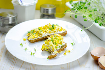 Healthy whole wheat bread with feta cheese, scrambled eggs and microgreens, proper nutrition sandwiches for breakfast
