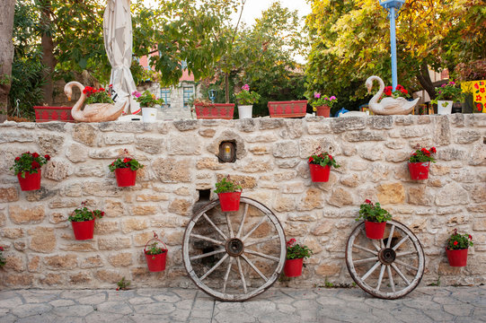 Red pots of flowers on a stone wall, Afitos, Halkidiki, Greece