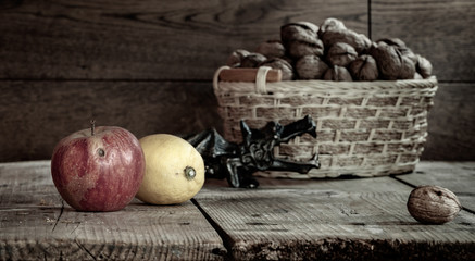 still life with a basket of nuts, Apple and lemon on a wooden table.