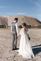 Beautiful elegant couple of newlyweds in love on a beautiful natural background of salt mountains and quarries