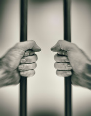 Hands on prison bars, first person view with motion blur