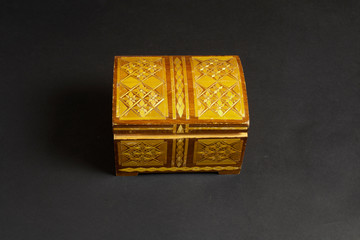 Closed handmade single casket on black textured paper background, wooden box, wooden chest,...
